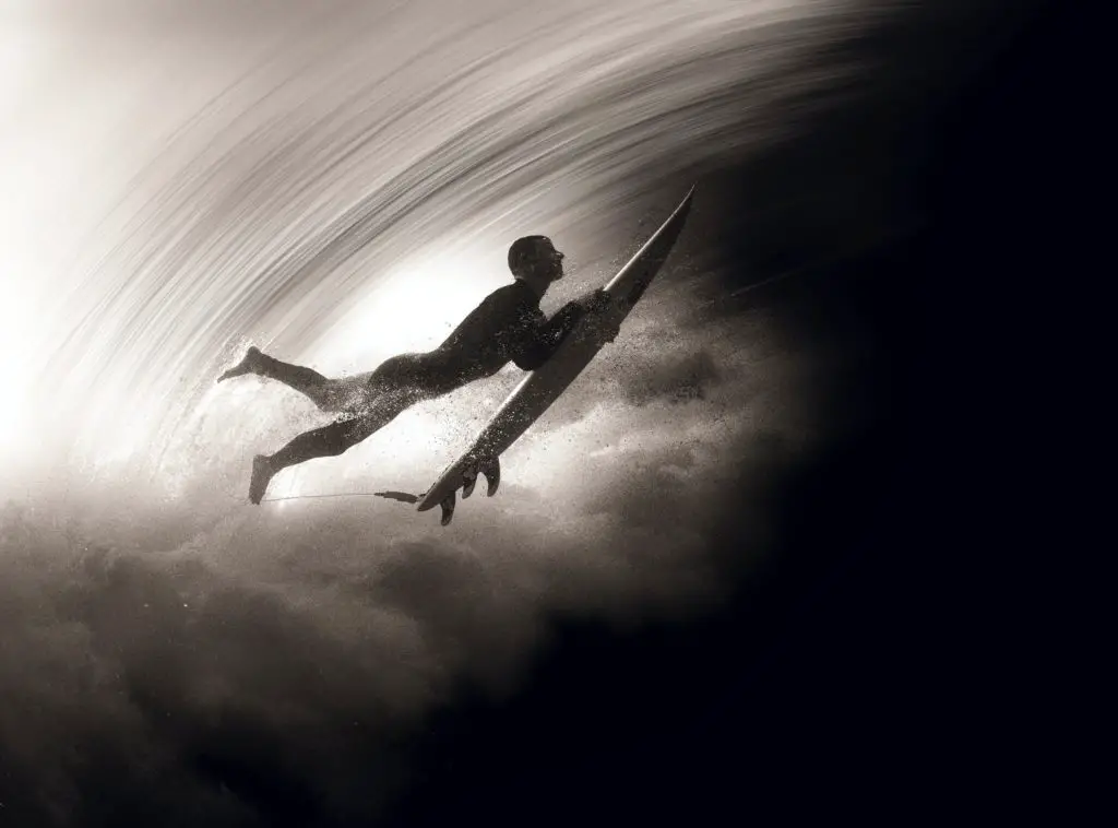 surfer under a wave